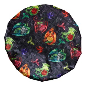 May include: A black satin sleep cap with a colorful print of dragons and roses. The dragons are in various colors, including red, green, blue, and yellow. The roses are red, yellow, and pink.