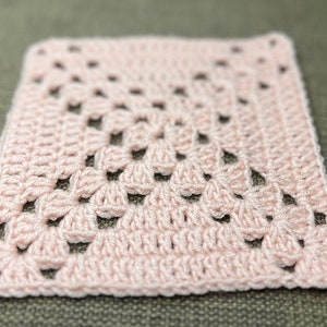 May include: A pink crocheted square with a diamond pattern.