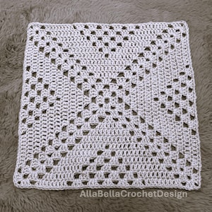 Könnte beinhalten: Ein quadratisches, cremefarbenes Häkelstück mit einem detaillierten Lochmuster. Das Design zeigt ein zentrales Blumenmotiv, das von geometrischen Formen umgeben ist. Der Text "AllaBellaCrochetDesign" ist in der unteren rechten Ecke sichtbar.