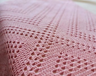 May include: A dusty pink crochet blanket featuring a geometric diamond pattern with openwork stitches. The text 'Pattern by Alla Bella' is visible at the top, and 'ALLABELLALONDON.BLOGSPOT.COM' is printed at the bottom of the image.