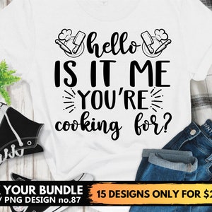 Peut inclure: T-shirt blanc avec du texte noir qui dit "hello is it me you're cooking for?" Le texte est entouré d'un graphique d'un chapeau de chef et de couteaux de cuisine.