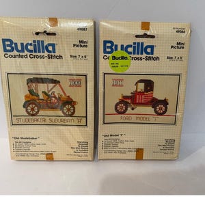 May include: Two Bucilla counted cross-stitch kits. One kit features a 1909 Studebaker Suburban "A" and the other a 1911 Ford Model "T". Each kit is a mini picture, measuring 7 x 5 inches.