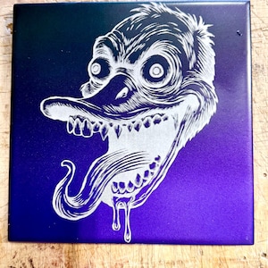 May include: Square tile with a gradient background of blue and purple. The tile features a white, stylized illustration of a grotesque duck-like creature with a long tongue and sharp teeth. The creature's expression is unsettling.