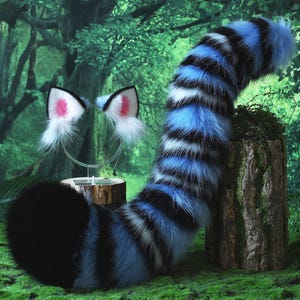 May include: A furry costume set featuring a black, blue, and white striped tail and matching cat ears with pink inner ear details. The tail is thick and curved, and the ears are attached to a silver headband. The set is designed for cosplay or costume use.