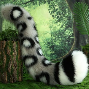 May include: A long, fluffy, white and black spotted tail with a black tip. The tail is made of faux fur and is perfect for adding a touch of whimsy to any costume or outfit.