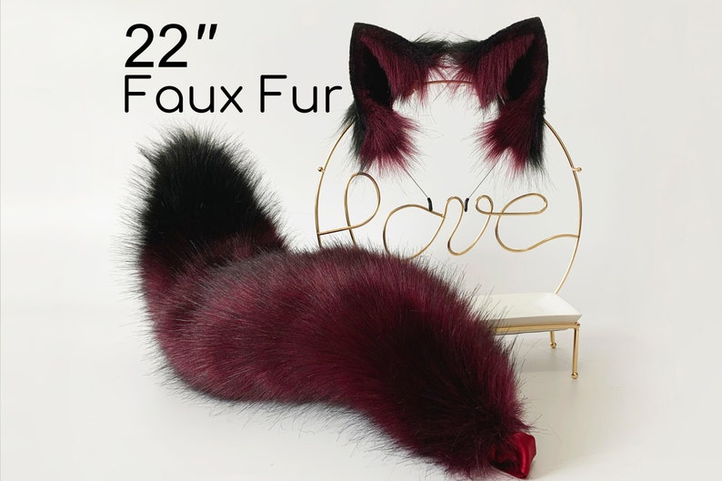 May include: A 22 inch long faux fur tail with a burgundy and black color gradient. The tail is displayed on a gold stand with a "love" sign.