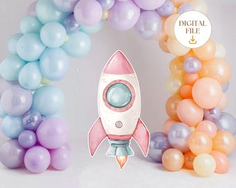 Puede incluir: Un cohete rosa y blanco con una ventana azul, rodeado de una guirnalda de globos pastel.
