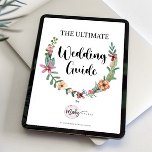 May include: A digital tablet displaying a wedding guide with a floral wreath design. The text reads "The Ultimate Wedding Guide" and "The Maby Studio".