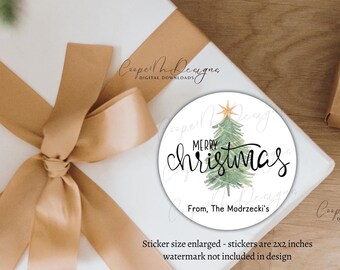 Könnte beinhalten: Ein runder, weißer Geschenkanhänger mit einem grünen Aquarell-Weihnachtsbaum und dem Text "Merry Christmas" in schwarzer Kursivschrift. Der Anhänger enthält auch den Text "From, The Modrzecki's" in schwarzer Schrift. Der Anhänger hat einen Durchmesser von 5 cm.
