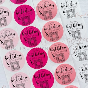 May include: Pink and white round stickers with the text "Buy the birthday girl a drink!" in black text. The stickers have a black and white QR code in the center.