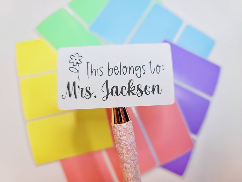 May include: White rectangular label with a black flower design and the text "This belongs to: Mrs. Jackson".