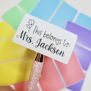 May include: White rectangular sticker with a small flower design and the text "This belongs to: Mrs. Jackson".