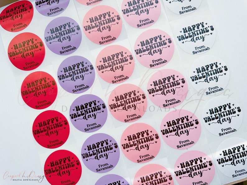 Puede incluir: Surtido de pegatinas redondas para el D&iacute;a de San Valent&iacute;n con el texto "Happy Valentine's Day" en letra cursiva negra sobre fondo rosa, morado, rojo o blanco. Las pegatinas tambi&eacute;n incluyen el texto "From Savannah".