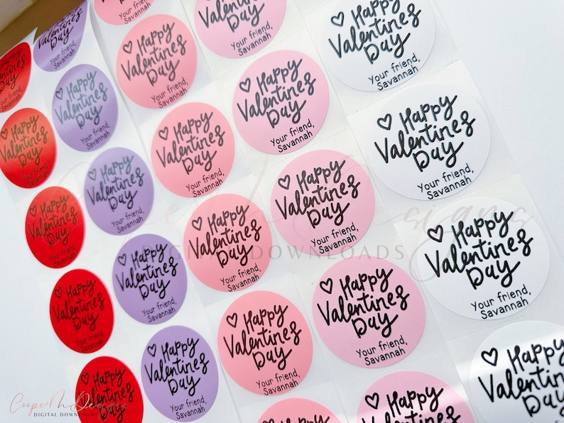 Puede incluir: Una hoja de pegatinas redondas con el texto "Happy Valentine's Day" en escritura cursiva negra. Las pegatinas est&aacute;n sobre un fondo blanco y tienen un fondo rosa, morado o blanco. El texto "Your friend, Savannah" est&aacute; impreso debajo del saludo en cada pegatina.