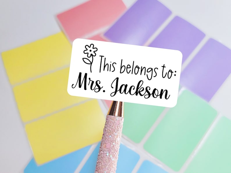 May include: White label with a black line drawing of a flower and the text "This belongs to: Mrs. Jackson".