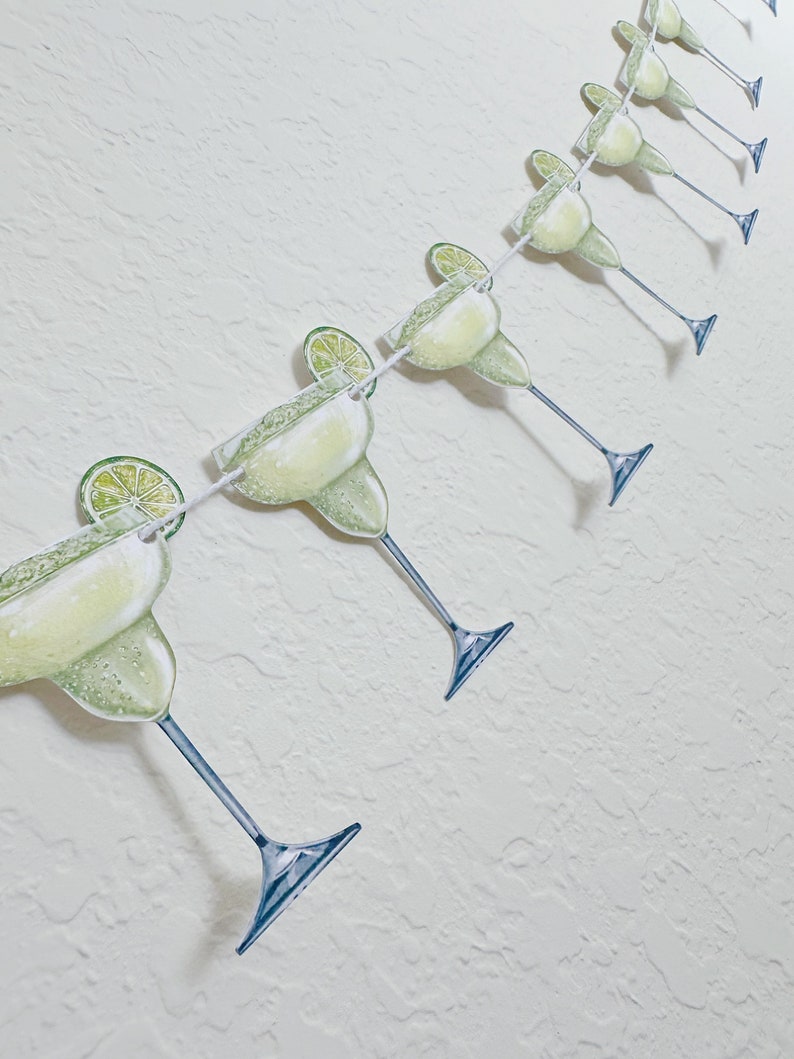 May include: A string of green margarita glass cutouts with lime wedges, perfect for a festive party decoration.