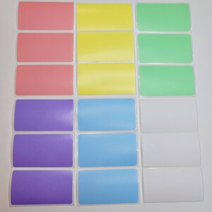 May include: A set of 18 blank labels in six different colors: pink, yellow, green, purple, light blue, and white. The labels are rectangular and have a glossy finish.