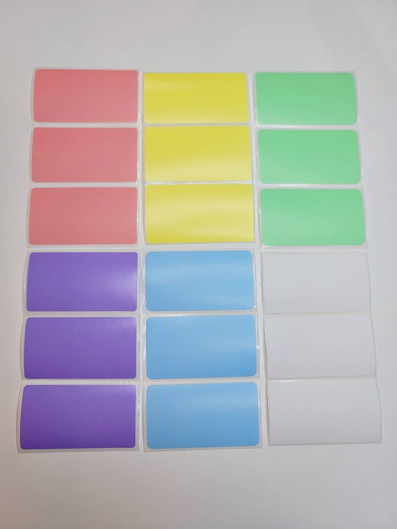 May include: A set of 18 blank labels in six different colors: pink, yellow, green, purple, light blue, and white. The labels are rectangular and have a glossy finish.