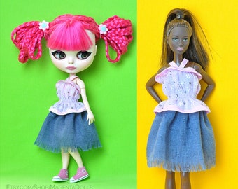 May include: Two dolls wearing matching outfits. The doll on the left has pink hair and a blue and pink dress. The doll on the right has brown hair and a blue and pink dress.