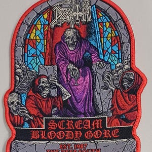 Puede incluir: Parche bordado con una figura esquelética con una túnica morada, sosteniendo una copa, dentro de un diseño de vidriera. El parche incluye el texto "DEATH" en la parte superior y "SCREAM BLOODY GORE" en la parte inferior, con "EST. 1987 THE DEEP SOUTH" debajo.