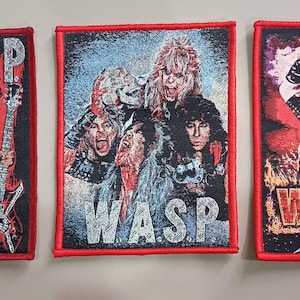 May include: Three embroidered W.A.S.P. band patches. Each patch has a black background and a red border. The patches feature images of the band members and the band's name in silver and red.