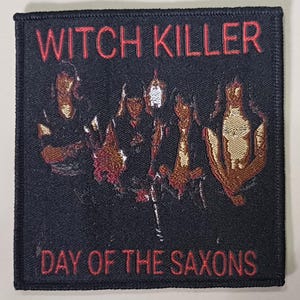May include: Black embroidered patch with the words "WITCH KILLER" above a graphic of four figures and the words "DAY OF THE SAXONS" below. The text and figures are in red against a black background.