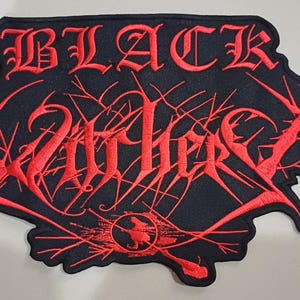 Puede incluir: Parche negro con texto bordado en rojo que dice "BLACK WATHERS" en una fuente gótica. El parche tiene un fondo negro con diseños rojos en forma de telaraña y un pequeño emblema circular con una silueta de bruja.