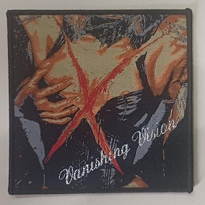 May include: Square patch with an illustration of a person's torso and arms, with a large red 'X' across the chest. The words "Vanishing Vision" are embroidered in white script on the lower right corner. The patch has a black border.