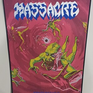 May include: A rectangular patch with the word "MASSACRE" in silver and blue lettering. The patch features a red background with green and yellow alien-like figures and the text "FROM BEYOND".