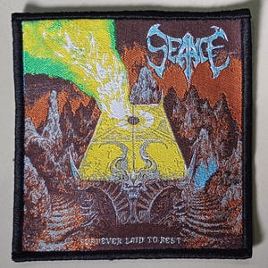 Op de afbeelding: Geborduurde patch met een zwarte rand. Het ontwerp toont een fantasielandschap in geel, groen, bruin en blauw. Het woord "SEANCE" staat bovenaan en de tekst "FOREVER LAID TO REST" staat onderaan de patch.