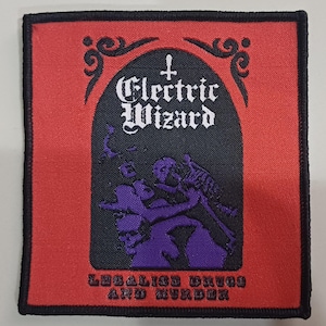 May include: A square patch with a black border and a red background. The centre features a black arch with the words "Electric Wizard" in white gothic font. Below, a purple illustration depicts figures. The text "Legalize Drugs and Murder" is at the bottom.