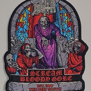 Puede incluir: Parche bordado que representa una figura esquelética con una túnica morada sosteniendo una copa, rodeada de otras figuras con túnicas rojas y calaveras. El parche tiene el texto "DEATH" en la parte superior y "SCREAM BLOODY GORE" en la inferior, con "EST. 1987 THE DEEP SOUTH".