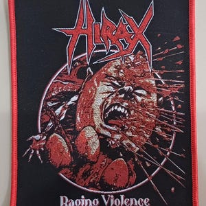 以下が含まれることがあります： 赤い縁取りのある黒いパッチ。白のギザギザフォントで「HIRAX」の文字が描かれています。パッチには、赤と白のディテールで叫ぶ顔と「Raging Violence」のテキストが描かれています。