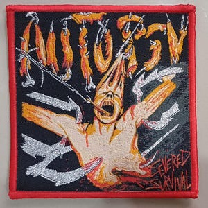 May include: A black and red embroidered patch featuring a graphic of a person with a bloody, open chest and the text "AUTOPSY" and "SEVERED SURVIVAL".