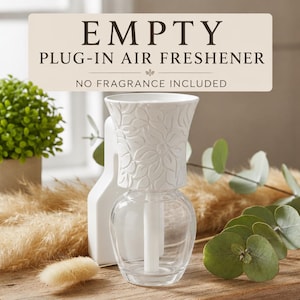 May include: An empty plug-in air freshener with a clear glass base and a white top featuring a raised floral pattern. The text on the image reads: EMPTY PLUG-IN AIR FRESHENER NO FRAGRANCE INCLUDED. The device has a central white wick component.
