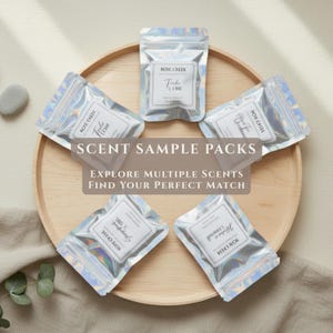 May include: Five small, iridescent, holographic resealable pouches arranged in a circle. Each pouch features a white rectangular label with the text Rose Creek and various scent names. The text Scent Sample Packs, Explore Multiple Scents, Find Your Perfect Match is overlaid in the center.