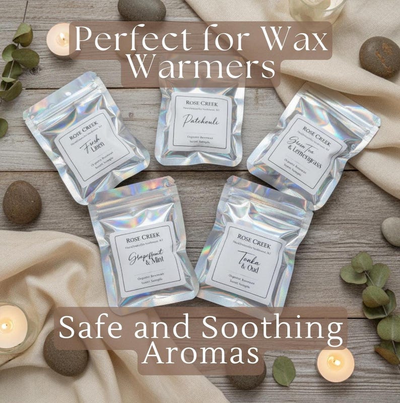 Op de afbeelding: Een bovenaanzicht toont vijf zilveren zakjes met wasmelts van Rose Creek, elk met een andere geur: Fresh Linen, Patchouli, Green Tea & Lemongrass, Grapefruit & Mint en Tonka & Oud. De tekst "Perfect for Wax Warmers" en "Safe and Soothing Aromas" is ook zichtbaar.