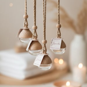 May include: Four hanging glass diffusers with light wood caps, each suspended by a thick jute rope featuring a small wooden bead. Each diffuser includes a small white rectangular tag with the handwritten text Lavender printed in black ink.