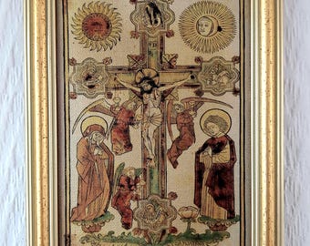 May include: A framed religious artwork featuring a crucifixion scene with figures and symbols. The artwork is in a gold-colored frame. The image depicts Jesus on the cross, with angels and other figures. The artwork has a vintage, antique style.