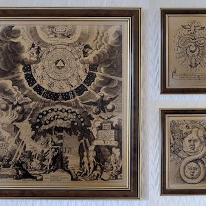 Può includere: Una collezione di stampe vintage incorniciate con intricate illustrazioni in bianco e nero. La stampa più grande presenta una mappa celeste dettagliata con figure e simboli. Altre stampe raffigurano un serpente, un volto con un serpente e un disegno con un serpente e una colomba.