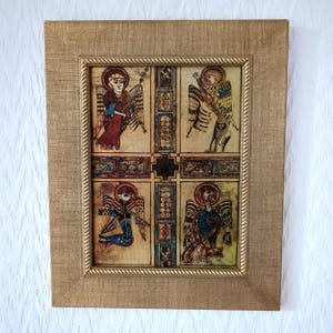 Peut inclure: &OElig;uvre d'art encadr&eacute;e avec quatre illustrations d'anges dans une grille. Les anges, avec des ailes et des halos, sont en rouge, bleu et or. Le cadre dor&eacute; a une bordure en forme de corde. Forme rectangulaire.