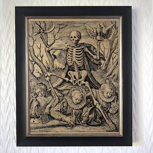 May include: Framed black and gold print featuring a skeletal figure holding a crescent moon and hourglass with wings. The artwork depicts figures in period clothing and is set against a backdrop of trees.
