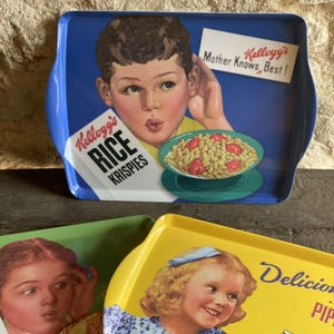 Op de afbeelding: Vintage metalen serveerbladen met kleurrijke illustraties. Eén dienblad toont een jongen met een kom ontbijtgranen en de tekst "Kellogg's Rice Krispies" en "Mother Knows Best!". Andere trays hebben afbeeldingen van kinderen.
