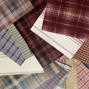 May include: An assortment of plaid fabric swatches in various colors and patterns. The swatches include shades of brown, red, blue, and green, with different plaid designs. Some swatches have a textured appearance, while others are smooth.