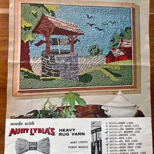 Può includere: Un kit per tappeto con ago da punzonatura che presenta un pozzo dei desideri con un tetto rosso e un cielo blu. Il kit include 70 yarde di filo in vari colori, tra cui sughero, blu chiaro, verde scuro, marrone chiaro, marrone, rosso, rosso scuro, grigio acciaio, grigio tortora, muschio, verde bosco e chartreuse. La dimensione del tappeto finito è di 61 cm per 91 cm.