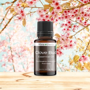 May include: A brown glass bottle of Clove Bud Essential Oil by Viva Doria. The bottle is labeled with the product name, "Pure Syzygium Aromaticum", "Food Grade", and "0.5 FL OZ | 15 ML".