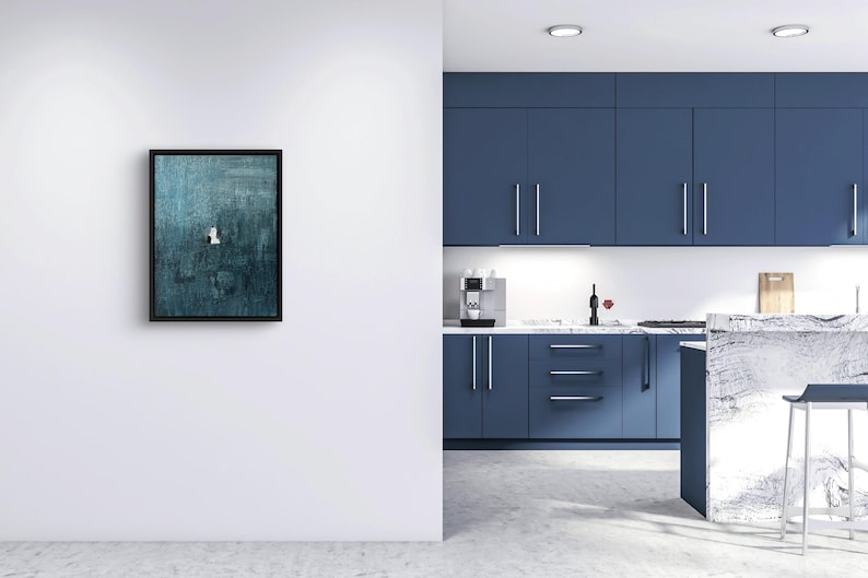May include: A rectangular wall art piece featuring a dark teal and blue textured abstract painting enclosed in a thin black frame. The artwork displays a small, centered white and black geometric accent against the deep, layered blue background.