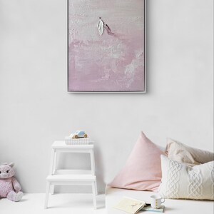 Pode incluir: Obra de arte abstrata emoldurada em prata. A pintura apresenta uma paleta texturizada em rosa claro e branco com formato de folha. A obra est&aacute; pendurada acima de um banco branco e uma cama pequena com almofadas.