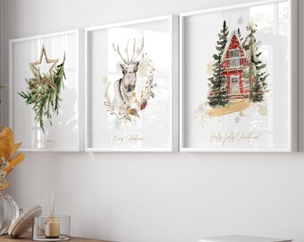 May include: Three framed watercolor prints with Christmas themes. One features a star with greenery, another a reindeer, and the last a red cabin in a snowy forest. The prints are displayed above a wooden cabinet.
