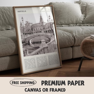May include: A framed black and white print featuring a detailed architectural image of a bridge and building in Seville, Spain. The print is in a wooden frame and includes the word "SEVILLA" at the top. The print is displayed on a wooden floor.